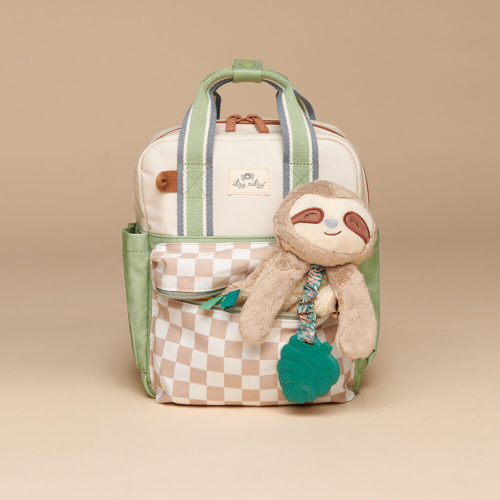 A beige and green "Itzy Ritzy Sweetie Strap Plus Bear Silicone Pacifier Clip" featuring a checkered front pocket and a stuffed sloth toy attached to the zipper, set against a neutral background.