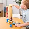 A young boy playing with a Melissa & Doug Stack & Count Wooden Parking Garage With 10 Cars at a table.