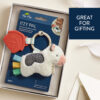 A baby toy set featuring a plush toy with a silicone teether attached, packaged in a cardboard box. The package includes a small photo of a baby holding the toy and text that says "Great for gifting.