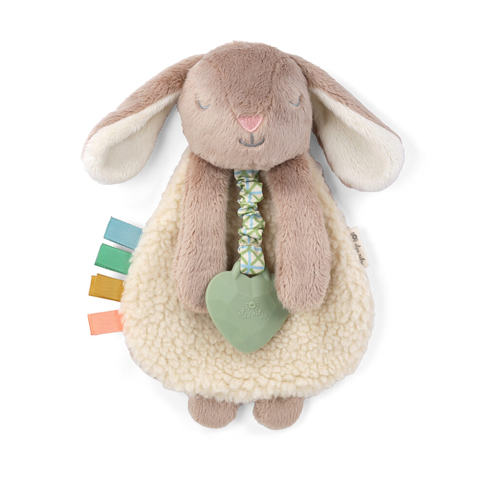 A fluffy, beige-and-white stuffed rabbit toy with long ears, a soft body, colorful fabric tags, and a green heart-shaped teething ring attached.