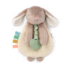 A fluffy, beige-and-white stuffed rabbit toy with long ears, a soft body, colorful fabric tags, and a green heart-shaped teething ring attached.