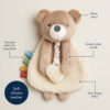 A plush bear toy made of minky velour and soft Sherpa fabric with a soft silicone teether, textured ribbon tabs, and a gentle crinkle sound feature.