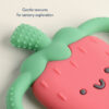 A close-up of the Itzy Ritzy Chew Crew Silicone Teether with Handles, shaped like an adorable cactus. It features green textured arms and a smooth, red, smiling body. The text reads, "Gentle textures for sensory exploration.