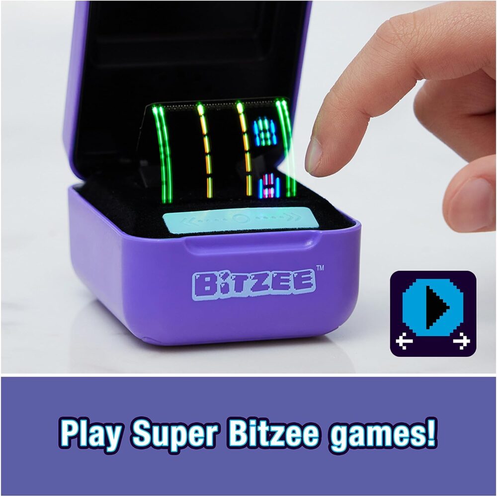 A hand interacts with a small, open purple box labeled "Spin Master Bitzee Interactive Toy Digital Pet," displaying colorful LED lights. Text below reads, "Play Super Bitzee games!" A play button icon is shown on the right.