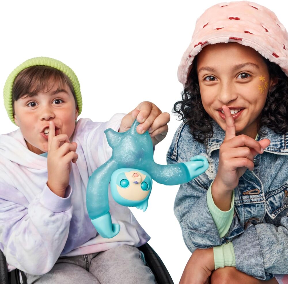 Two children with a toy make "shh" gestures, suggesting quietness. One wears a green beanie and white hoodie, the other sports a pink bucket hat and denim jacket. The toy is blue and humanoid.