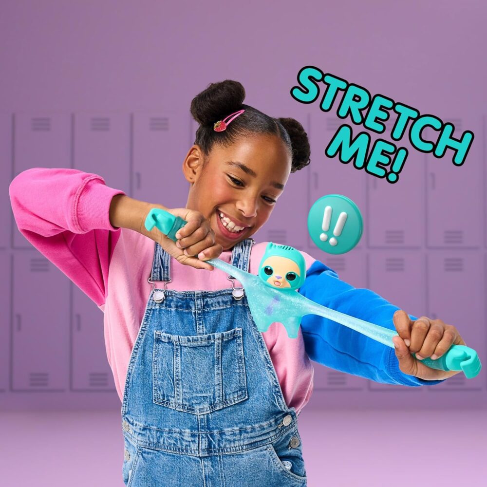 A smiling child in overalls and a colorful sweater holds and stretches a green gooey toy with the text "STRETCH ME!" and an exclamation mark symbol next to the toy. Background features lockers.