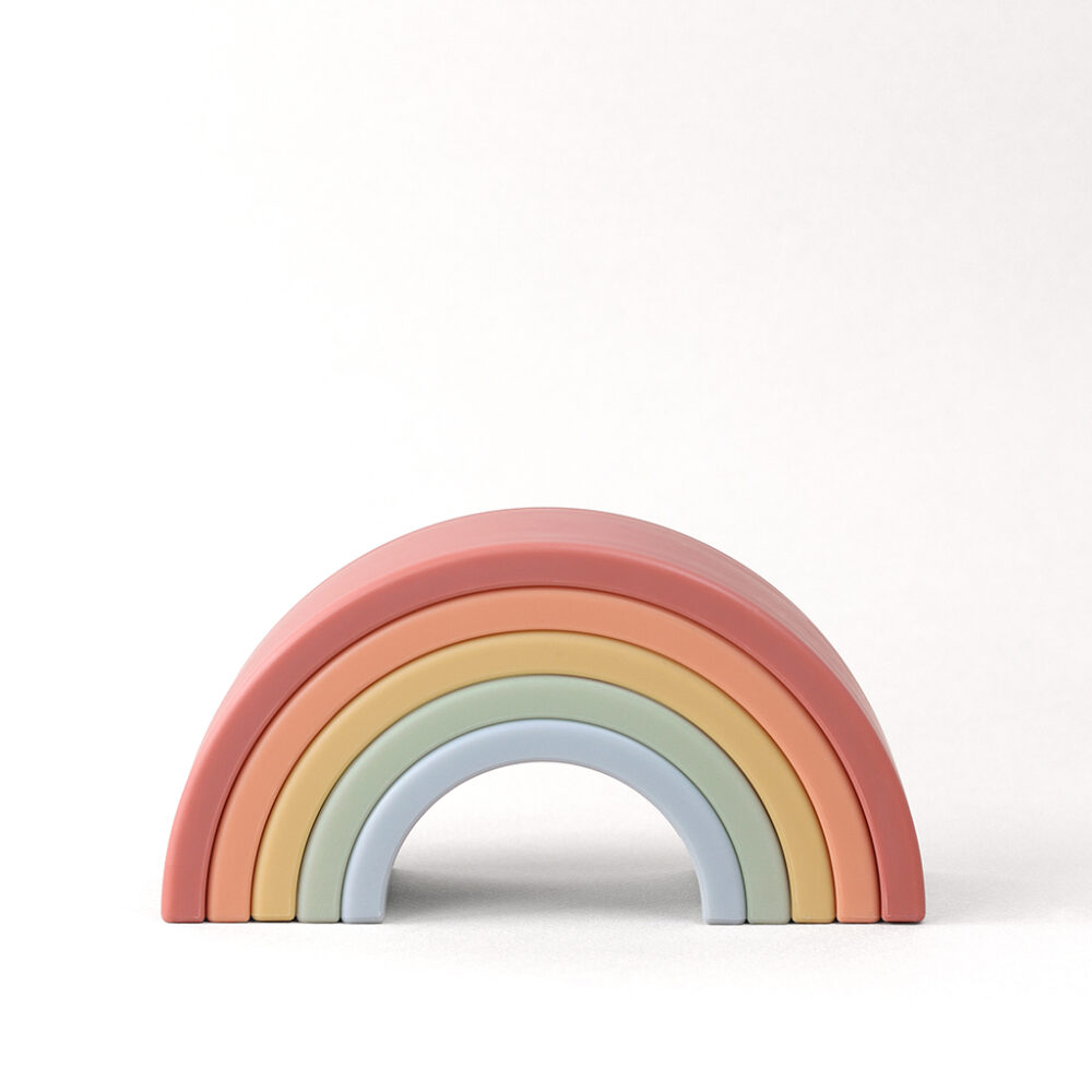 A pastel-colored wooden rainbow toy with six arches, arranged in descending size order against a light background.