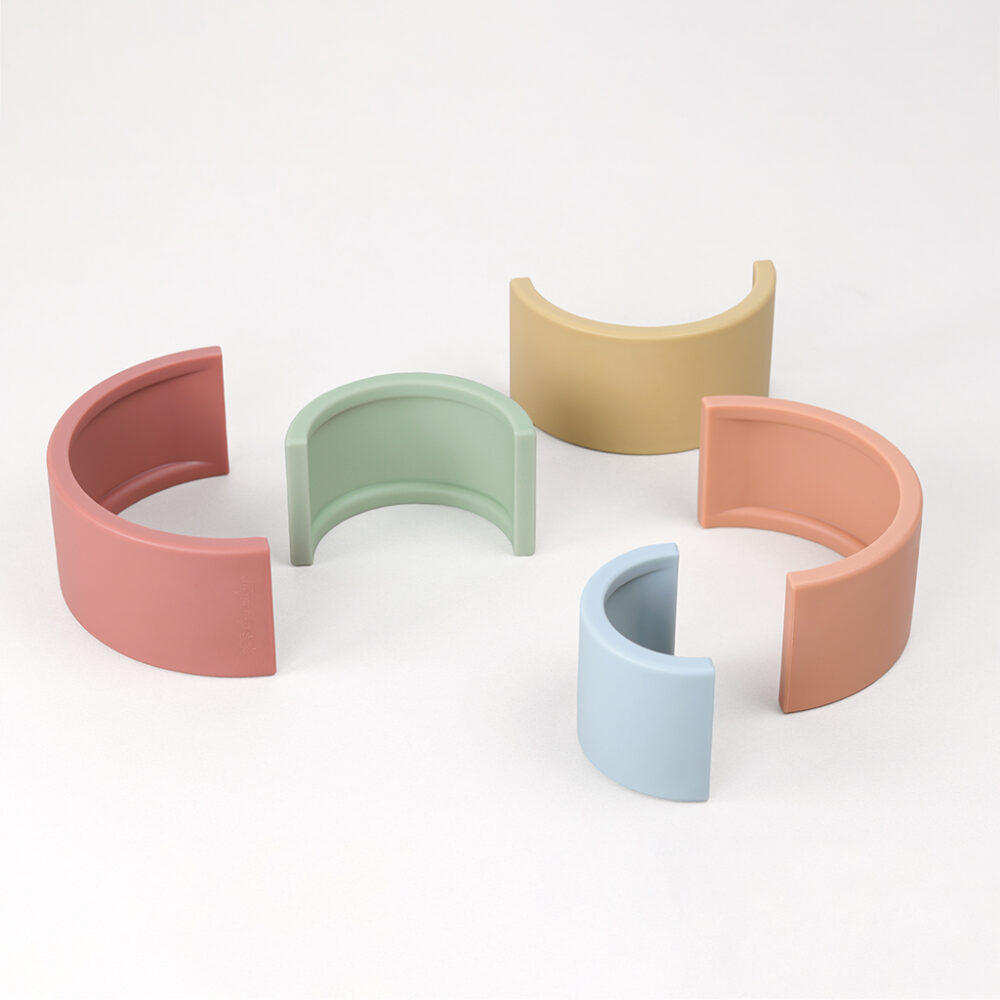 Five pastel-colored, semicircular, plastic bracelet organizers displayed against a plain white background.