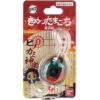 A packaged toy keychain labeled "Tamagotchi Nano x Demon Slayer - Dance of The Fire God" from Bandai, featuring Japanese text and an illustrated character on the packaging. The toy includes a small screen and buttons for interaction.