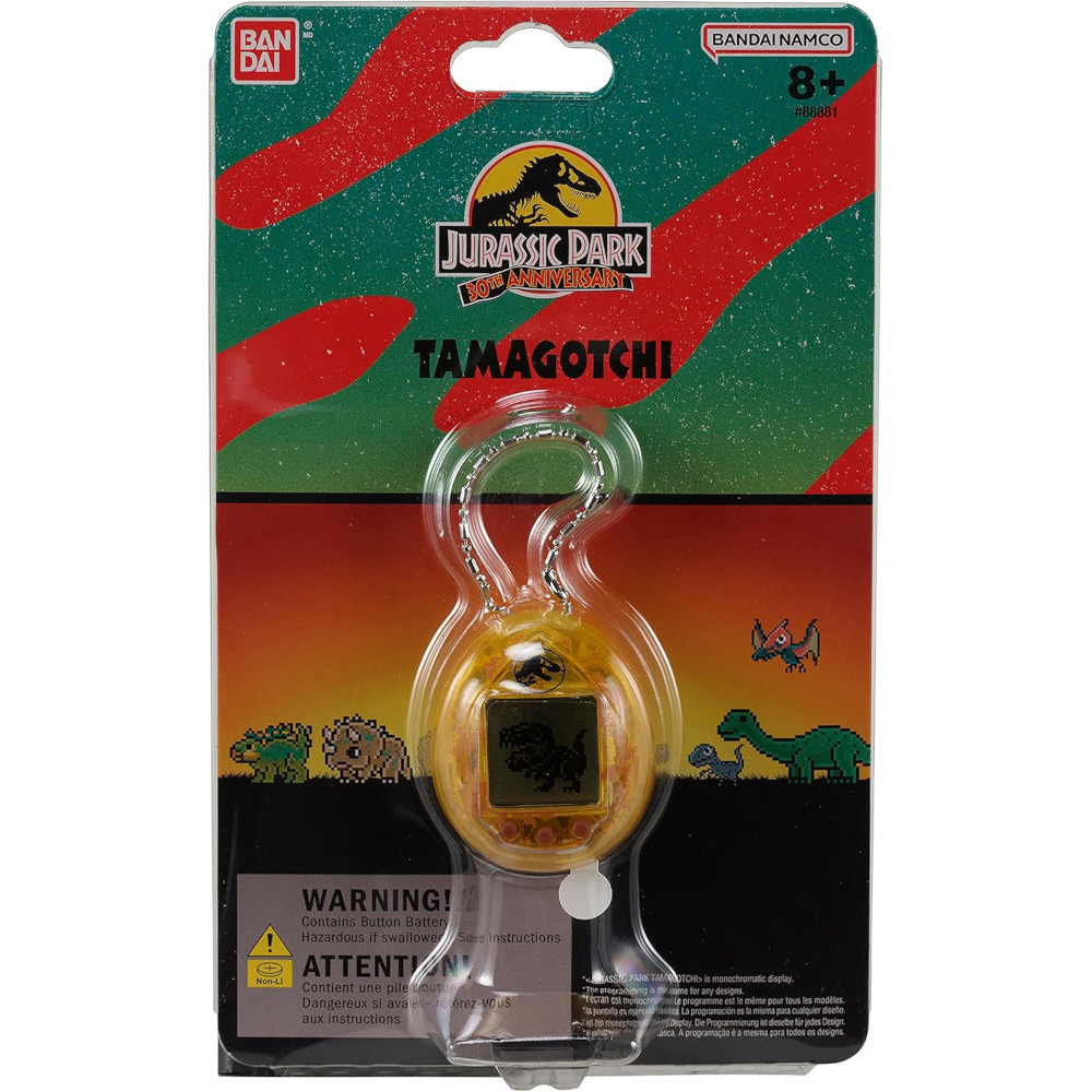 A Jurassic Park-themed Tamagotchi Nano x Jurassic Park 30th Anniversary - Dinosaur Amber in packaging by Bandai Namco for ages 8 and up. The packaging includes dinosaur images and warnings.