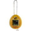 The Tamagotchi Nano x Jurassic Park 30th Anniversary - Dinosaur Amber is a yellow, egg-shaped handheld electronic toy with a keychain and a small screen featuring a pixelated dinosaur image.