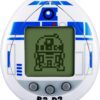 An electronic handheld game featuring a design resembling R2-D2 from Star Wars, with an LCD screen displaying a pixelated image of R2-D2 is the Tamagotchi Nano x Star Wars - R2-D2 Hologram.