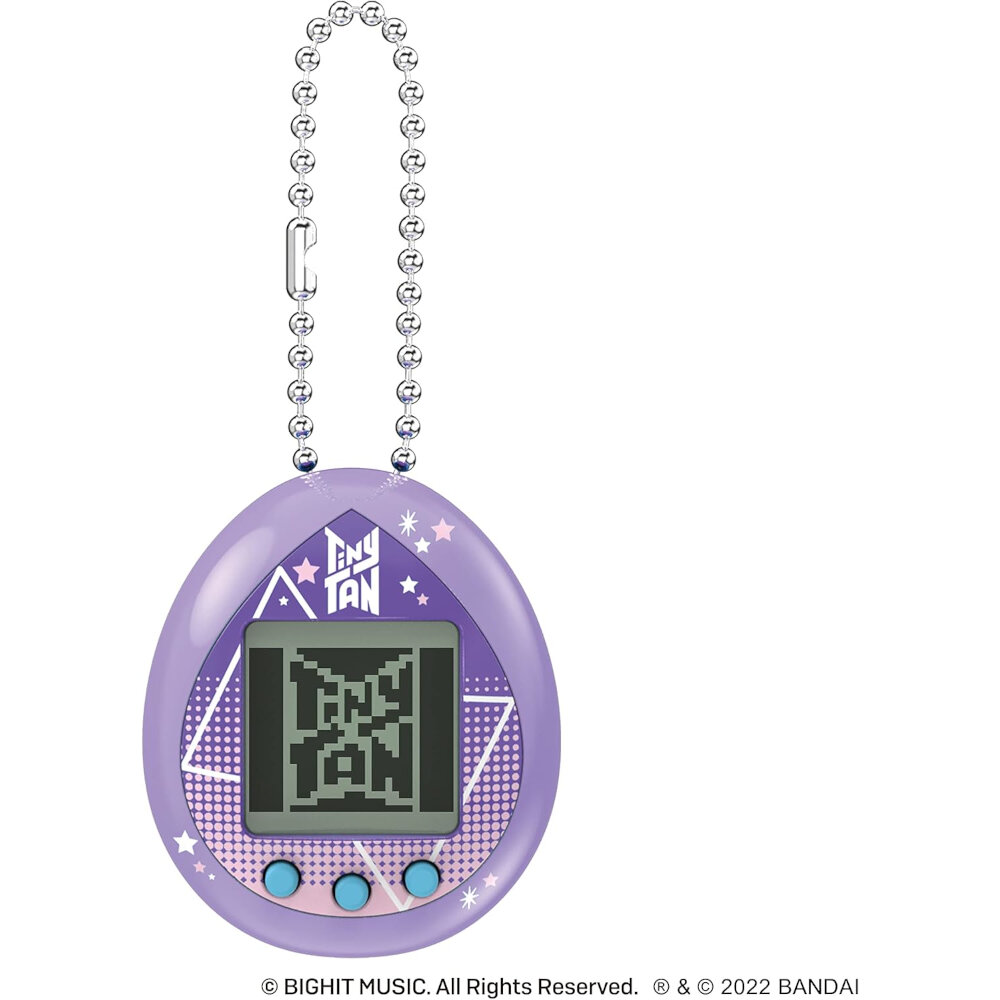 A small, purple, egg-shaped digital pet device with a pixelated screen on a ball chain. The words "ENJ EYE" and star patterns are printed on the casing. Text at the bottom indicates the brand.