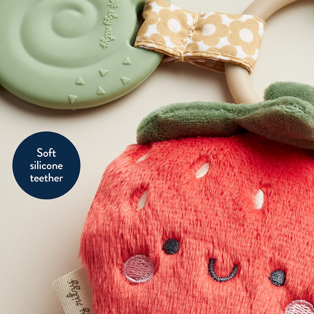 A soft silicone teether shaped like a red strawberry with a smiling face, paired with a green leaf and a polka dot bow handle called Itzy Ritzy - Itzy Pal - Plush Pal Infant Toy with Silicone Teether.