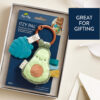 A Itzy Ritzy - Itzy Pal - Plush Pal Infant Toy with Silicone Teether in a gift box with a label that reads "itzy pal," featuring a plush avocado and accessories. text on the image says "great for gifting.