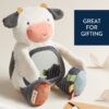 A plush toy shaped like a cow with a mirror on its belly sits on a surface next to pieces of ribbon. A sign reads "Great for Gifting.