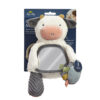 A plush cow toy with various textures and features, including a mirror on its tummy and a teether attached. Background packaging details sensory aspects.