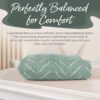 A Breastfeeding Boss in green muslin, resting on a cushioned surface, with text highlighting its exceptional softness and comfort for both baby and parent.