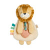 A plush toy in the shape of a lion with a fluffy mane, a beige body, colorful ribbons on one side, and a small heart accessory on the front.