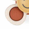 Close-up image of a beige, round object with a smooth surface and a textured orange circle, plus a section featuring a smiling face.