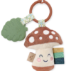 A Itzy Ritzy - Itzy Pal - Plush Pal Infant Toy with Silicone Teether featuring a smiling mushroom plush with a teething leaf and colorful rings attached to a wooden ring.